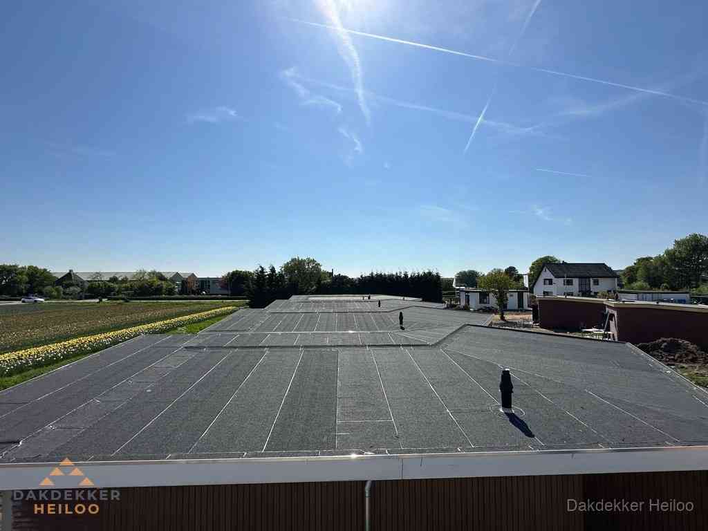 Groot plat dak met bitumen dakbedekking op bedrijfspand in Heiloo Groot plat dak met bitumen dakbedekking op bedrijfspand in Heiloo