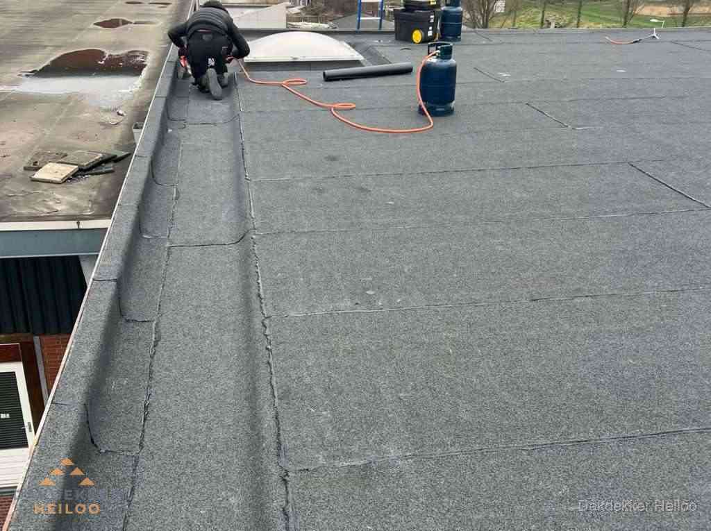 Dakdekker repareert bitumen dakbedekking op groot plat dak in Heiloo Dakdekker repareert bitumen dakbedekking op groot plat dak in Heiloo