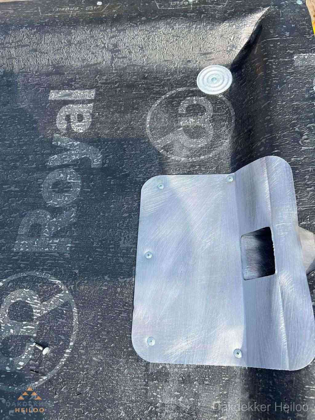 Dakdoorvoer met metalen afvoerplaat op bitumen dak in Heiloo Dakdoorvoer met metalen afvoerplaat op bitumen dak in Heiloo