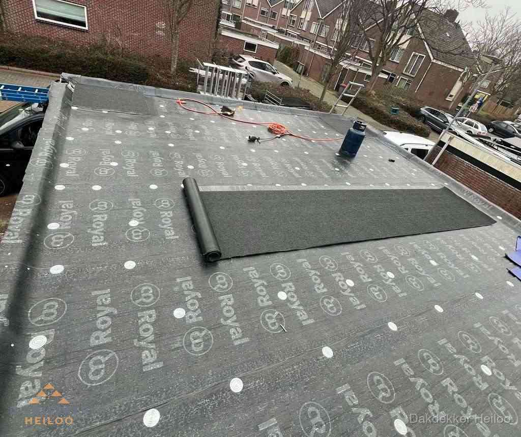 Dakdekker aan het werk met gasbrander op plat bitumen dak in Heiloo Dakdekker aan het werk met gasbrander op plat bitumen dak in Heiloo